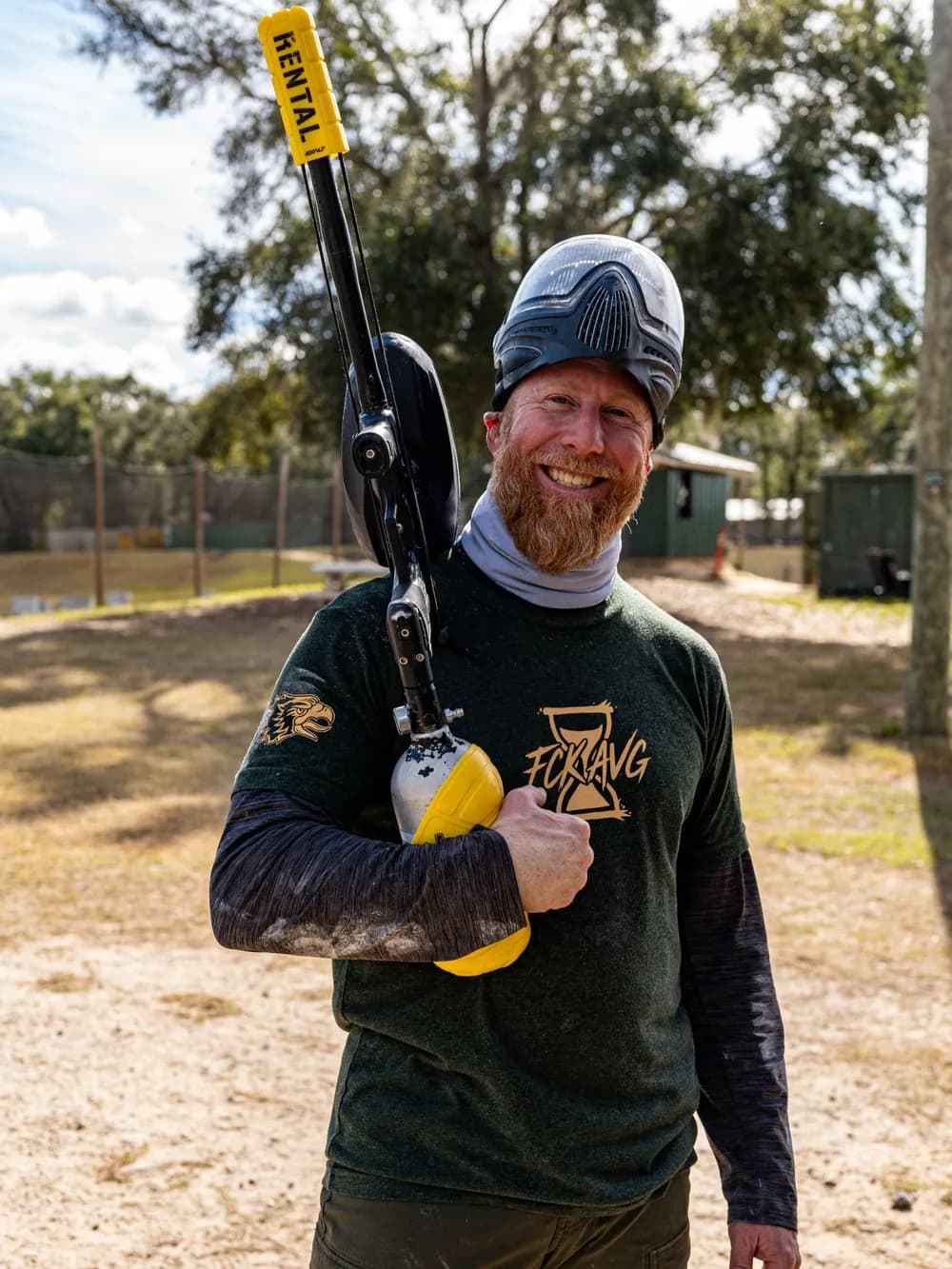 Brian McNally in an FCK AVG shirt with a paintball marker at a men's group outing