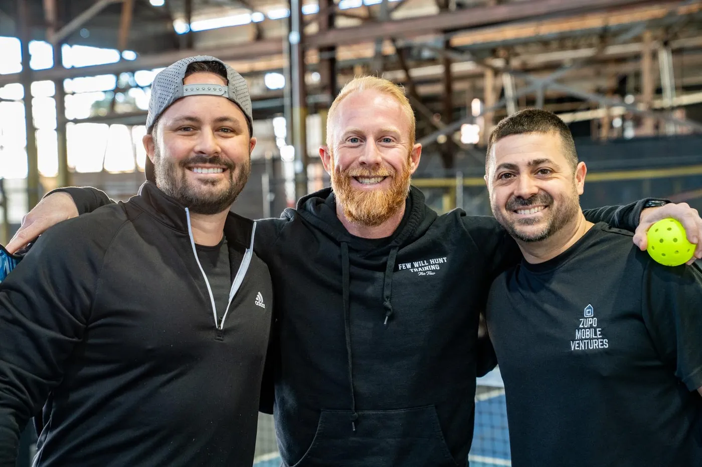 Brian McNally with two friends from his men's group on a pickleball court