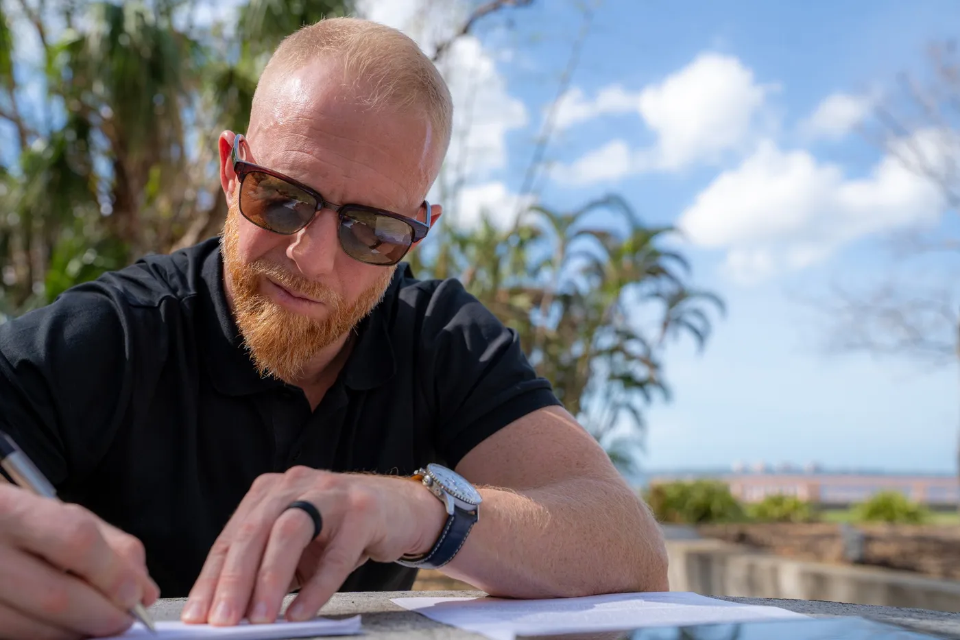 Brian McNally writing at an outdoor table